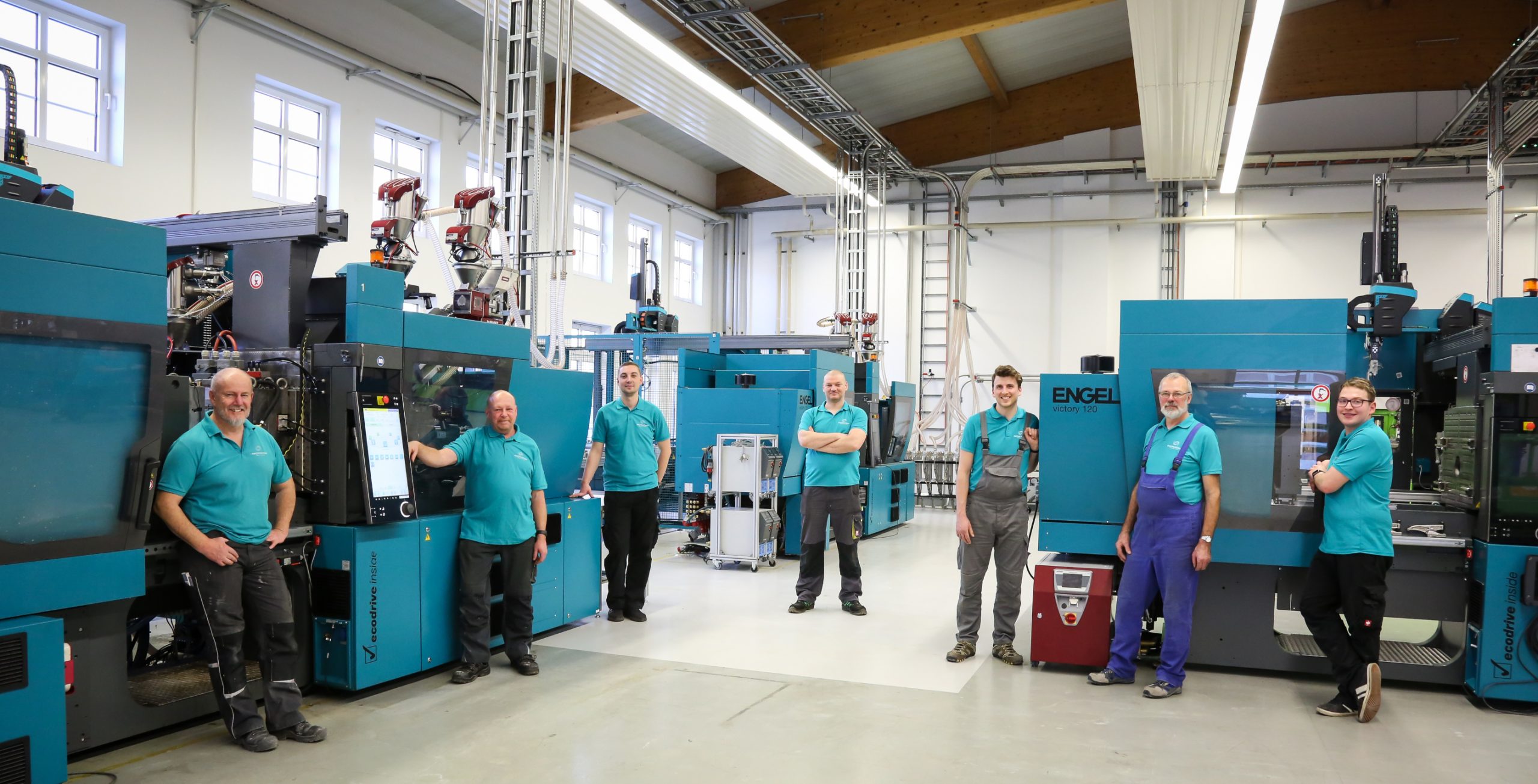 gesamte Team der Produktion vor dem Maschinenpark